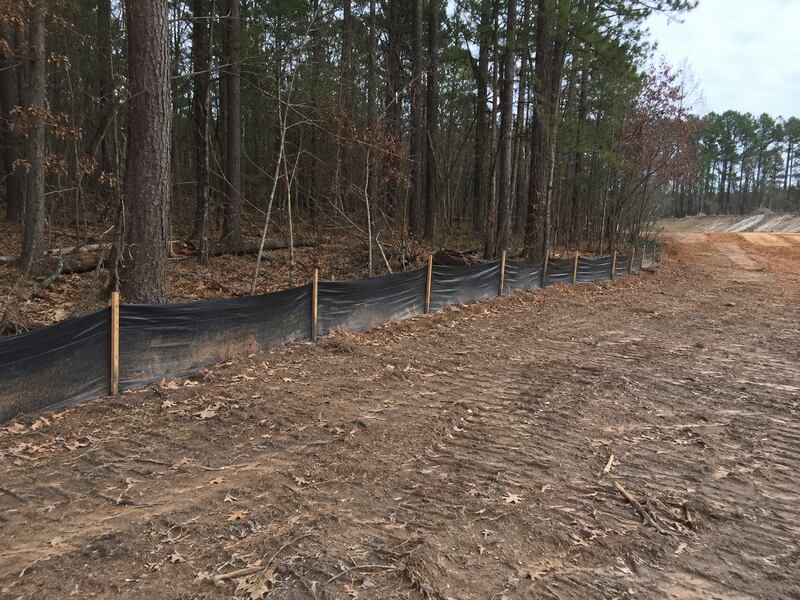 Black silt fence along a woodland edge
