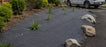 Commercial weed barrier fabric installed in a landscape bed
