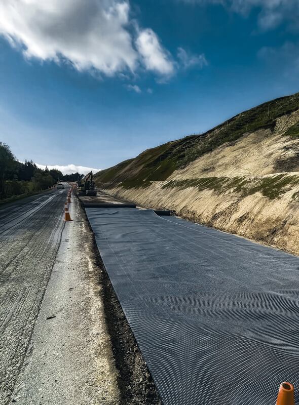 Mirafi H2Ri woven geotextile rolled out for road stabilization
