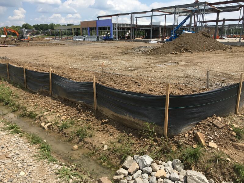 Silt fence around a construction site with steel framing beyond
