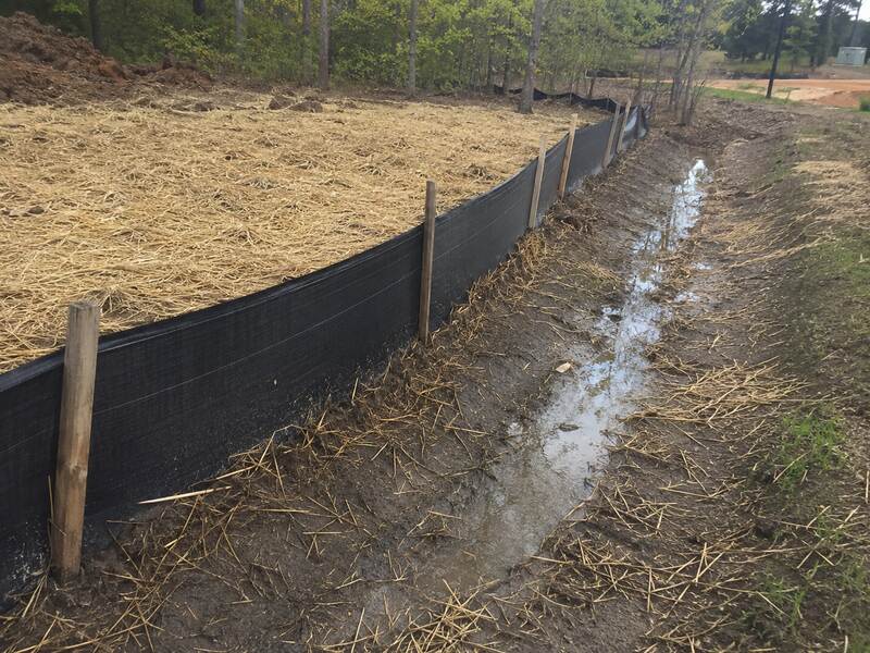 Silt fence along a muddy drainage ditch
