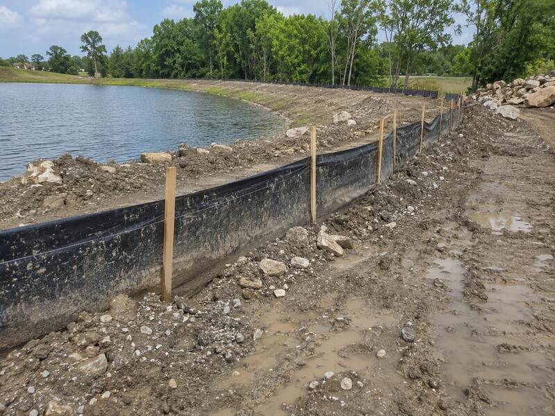 Silt fence along a muddy shoreline for erosion control
