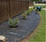 Weed barrier fabric installed in a curved residential garden bed
