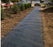 Weed control fabric along a long residential planting strip
