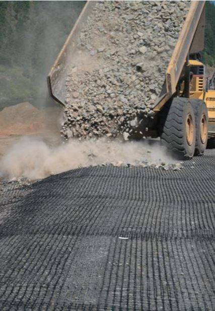 dump truck unloading rocks on MIRAFI BXG110 Geogrid 